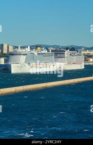 Marseille, France - 03 décembre 2024 : grands navires de croisière amarrés au port de Marseille avec des immeubles de grande hauteur et des montagnes lointaines mettant en valeur le fus Banque D'Images