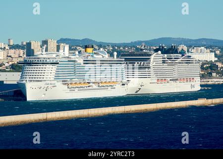 Marseille, France - 03 décembre 2024 : deux grands navires de croisière amarrés au port de Marseille, avec la ville et les montagnes en arrière-plan, mettant en vedette le Banque D'Images