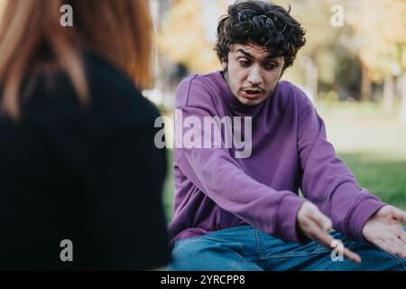 Jeune couple ayant une discussion intense en plein air dans le parc Banque D'Images