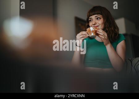 Jeune femme prendre une tasse de café à la maison Banque D'Images