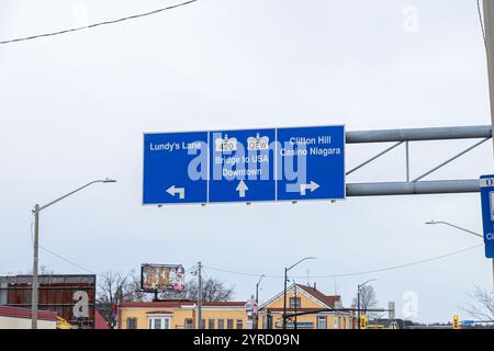 Panneaux routiers aériens menant à Lundy’s Lane, Bridge to USA et Clifton Hill Casino Niagara, avec des bâtiments en arrière-plan. Banque D'Images