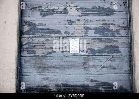 Panneau de stationnement pour handicapés sur la porte roulante au dépôt de bouteilles Return-It sur la 72e Avenue à Surrey, Colombie-Britannique, Canada Banque D'Images