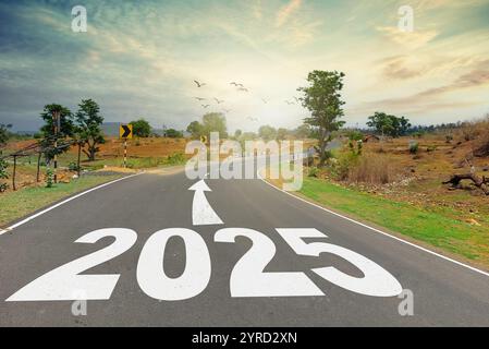 Concept du nouvel an 2025. Texte 2025 écrit sur la route au milieu de la route au coucher du soleil. Début du nouvel an Banque D'Images