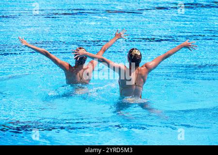 Duo de nageurs artistiques exécutant une routine chorégraphiée synchronisée dans la piscine Banque D'Images