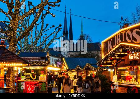 Stands festifs au Wantermaart (marché d'hiver) à Luxembourg, avec les flèches de la cathédrale notre-Dame en arrière-plan Banque D'Images