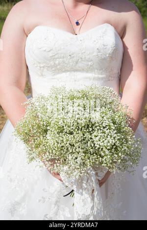 Gros plan de mariée tenant le bouquet Gypsophila dans la robe de mariée en dentelle blanche Banque D'Images