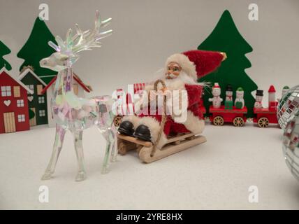 Père Noël sur un traîneau et renne en verre. Composition minimale Banque D'Images
