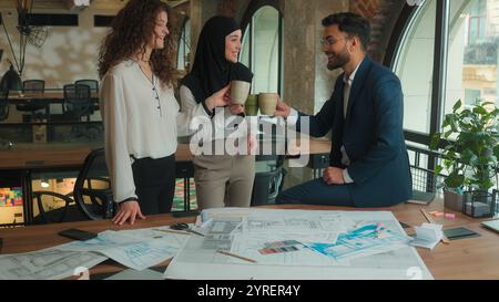 Équipe architectes entrepreneurs ingénieurs collègues d'affaires Arabian Muslim Caucasian homme d'affaires femmes d'affaires boivent pause café heureux homme détendu Banque D'Images