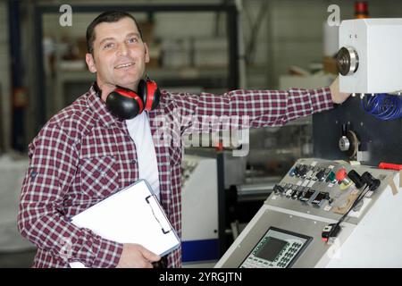 ingénieur appuie sur un bouton dans une usine Banque D'Images