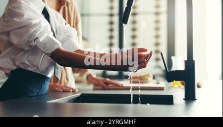 Maison, parent et fille avec se laver les mains dans la cuisine pour l'hygiène, les germes et les bactéries. Appartement, les gens et l'enfant en famille avec de l'eau à l'évier pour la saleté Banque D'Images