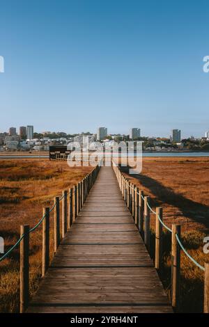 Longue passerelle en bois traversant les marais à porto skyline à vila nova de gaia sous le ciel bleu clair de estuario do douro Banque D'Images