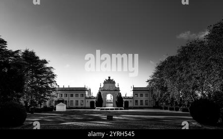 La lumière du soleil illumine la grande porte d'entrée du palacio de seteais à sintra, au portugal, créant un contraste saisissant avec le ciel sombre dans cette blac Banque D'Images