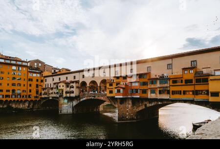 Ponte vecchio, un pont historique à florence, en italie, se prélasse de la lueur chaude du soleil couchant, de ses boutiques colorées et de ses arches en pierre Banque D'Images