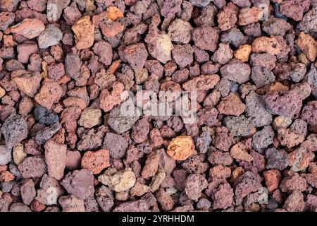 Une vue détaillée du gravier volcanique mettant en valeur ses couleurs vibrantes et sa texture unique cette image capture diverses nuances et formes irrégulières du volcan Banque D'Images