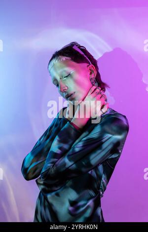 Une image frappante capturant une femme stylisée dans un style futuriste sur un fond violet vibrant, mettant l'accent sur les thèmes de la métaverse et de la modernité Banque D'Images