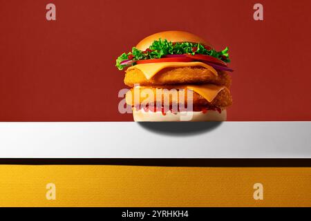 Un hamburger de poulet croustillant avec des légumes frais, du fromage et un petit pain moelleux, affiché sur un fond vibrant Banque D'Images