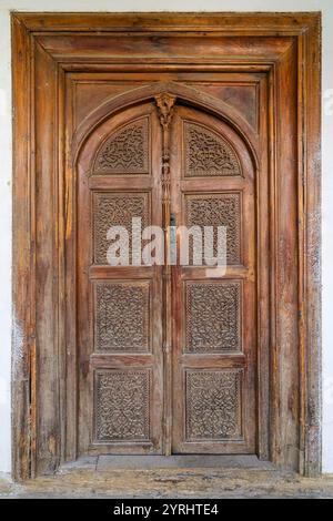 Gros plan de l'ancienne porte traditionnelle en bois avec motif floral et géométrique de sculpture, Istaravshan, Sughd, Tadjikistan Banque D'Images