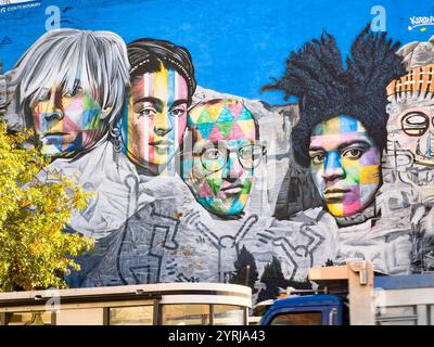 Murale de Street art dynamique avec des portraits colorés d'artistes emblématiques sur un fond bleu vif dans un cadre urbain avec andy warhol Frida Kahlo Banque D'Images