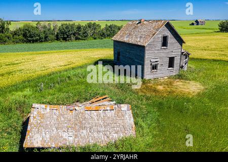 Une petite maison ancienne se trouve dans un champ d'herbe. La maison est dans une zone rurale et il est abandonné Banque D'Images