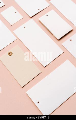 Étiquettes de prix blanches, étiquettes vierges avec différentes formes et tailles sur un fond beige. Vue de dessus. Copier l'espace Banque D'Images