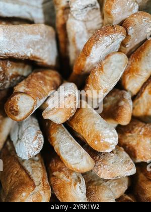 Un gros plan de baguettes rustiques fraîchement cuites avec croûte dorée et saupoudré de farine. Les vitrines de pain artisanal, vue de dessus Banque D'Images