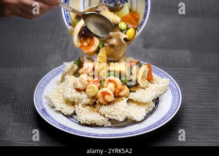 Riz chinois croustillant ou grésillé avec sauce épaissie, fruits de mer et légumes. Cuisine du Sichuan. Banque D'Images