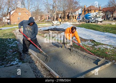 Detroit, Michigan - les ouvriers versent et finissent le béton pour les sentiers pédestres dans Three Mile Park dans le quartier Morningside de Detroit. Banque D'Images