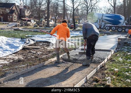 Detroit, Michigan - les ouvriers versent et finissent le béton pour les sentiers pédestres dans Three Mile Park dans le quartier Morningside de Detroit. Banque D'Images