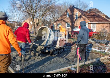 Detroit, Michigan - les ouvriers versent et finissent le béton pour les sentiers pédestres dans Three Mile Park dans le quartier Morningside de Detroit. Banque D'Images