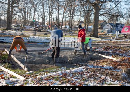 Detroit, Michigan - les ouvriers versent et finissent le béton pour les sentiers pédestres dans Three Mile Park dans le quartier Morningside de Detroit. Banque D'Images