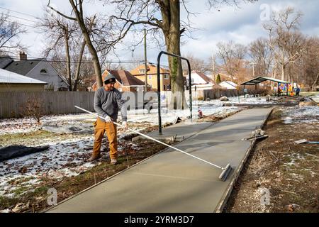 Detroit, Michigan - les ouvriers versent et finissent le béton pour les sentiers pédestres dans Three Mile Park dans le quartier Morningside de Detroit. Banque D'Images