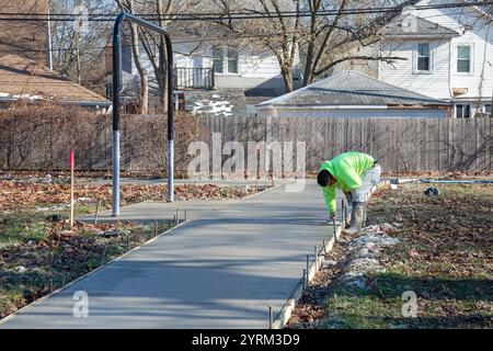 Detroit, Michigan - les ouvriers versent et finissent le béton pour les sentiers pédestres dans Three Mile Park dans le quartier Morningside de Detroit. Banque D'Images