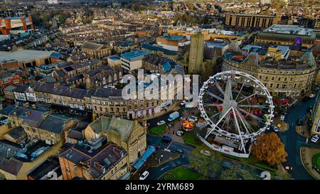 Vue aérienne d'un centre-ville avec une grande roue, de nombreux bâtiments et une rue courbe. L'architecture est principalement en pierre, avec un mélange de Banque D'Images