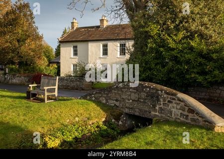 Royaume-Uni, comté de Durham, Cotherstone, Brook Lea, maison et banc au pont sur le bord du village vert Banque D'Images