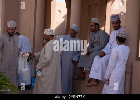 hommes omanais parlant dans un groupe par étal de légumes nizwa suq nizwa oman moyen-orient Banque D'Images