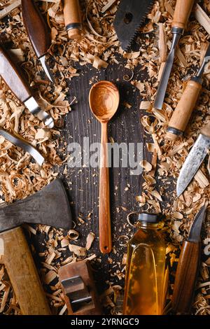 Cuillère en bois artisanale avec tas de limailles en bois avec différents outils de menuiserie manuelle. Concept de fabrication artisanale Banque D'Images