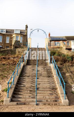 Les marches en fer à cheval à Newbiggin-by-the-Sea, Northumberland, Angleterre. Les marches mènent à et depuis la promenade dans la ville balnéaire. Banque D'Images
