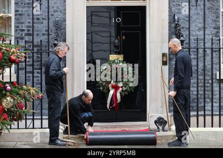 Tapis rouge déroulé devant la porte d'entrée du 10 Downing Street, cette fois pour la visite de l'émir du Qatar, Londres, Royaume-Uni Banque D'Images