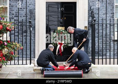 Tapis rouge déroulé devant la porte d'entrée du 10 Downing Street, cette fois pour la visite de l'émir du Qatar, Londres, Royaume-Uni Banque D'Images