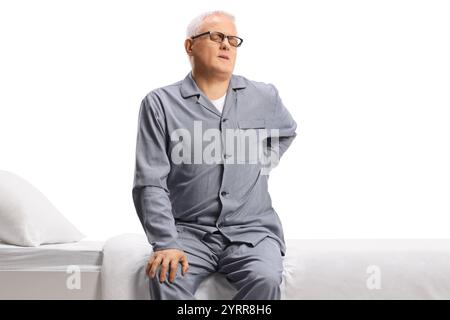 Homme mature en pyjama souffrant de maux de dos isolé sur fond blanc Banque D'Images