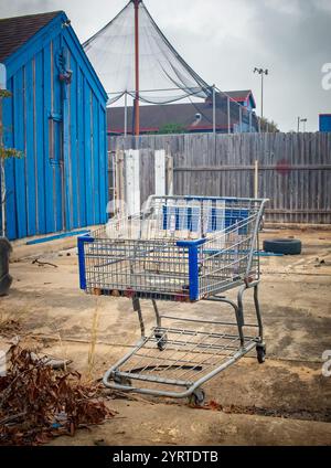 Vieux chariot métallique abandonné à côté d'une décharge urbaine abandonnée. Photo prise à Houston Texas Banque D'Images