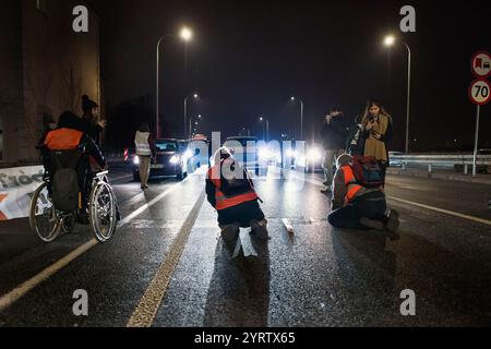 Les manifestants de l'organisation Last Generation lancent un blocus lors d'une manifestation contre la politique climatique du premier ministre polonais Donald Tusk. Les militants du mouvement climatique de dernière génération (Ostatnie Pokolenie) ont depuis la semaine dernière intensifié une campagne de longue date de blocage des routes clés pendant les heures de pointe, certains manifestants se collant aux routes. Ils demandent que tout le financement des nouveaux projets de voies rapides et autoroutières soit plutôt orienté vers l'amélioration des transports publics et que des billets mensuels bon marché soient introduits pour l'utilisation des transports publics. Prime Minis Banque D'Images