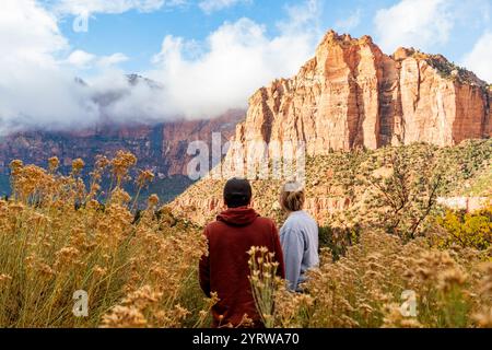 Couple regarde les magnifiques falaises du parc national de Zion pendant l'heure dorée Banque D'Images