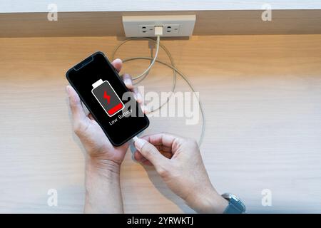 Fermez les mains de l'homme à l'aide de l'écran de batterie de batterie de charge faible de téléphone intelligent, homme d'affaires tenant un smartphone avertissement de batterie faible sur un téléphone mobile. Nee Banque D'Images