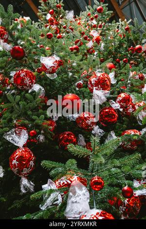 3-12-2024 Zurich, Suisse. Grand sapin de Noël à l'intérieur de la gare principale de Zurich décoré de boules de chocolat Lindt rouges. Gros plan, regardant vers le haut plan, non Banque D'Images