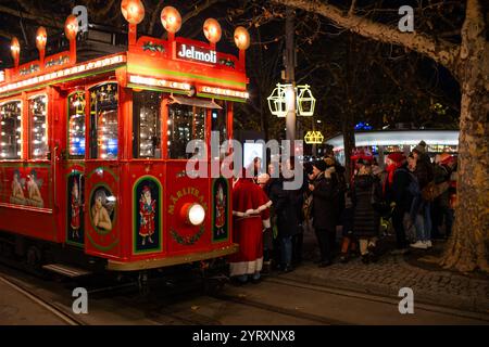 3-12-2024 Zurich, Suisse. Les gens se rassemblant autour pour monter à bord du célèbre thème de Noël décoré Jelmoli vintage tram en fin de soirée. Banque D'Images