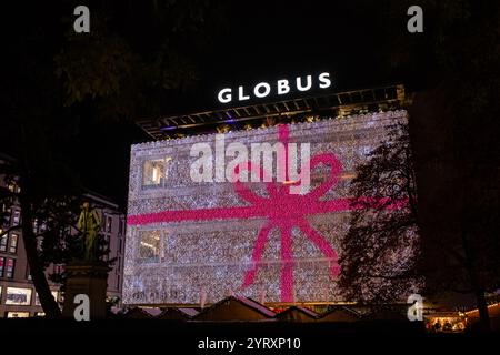 3-12-2024 Zurich, Suisse. Célèbre centre commercial Globus sur Bahnhofstrasse entièrement recouvert de lumières décoratives de Noël. Scène nocturne, wid Banque D'Images