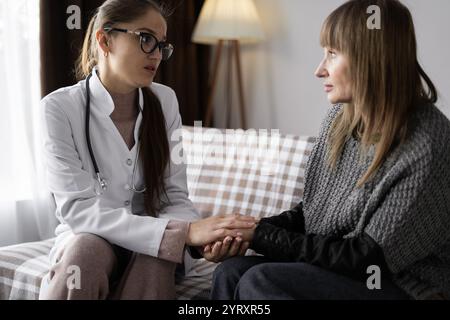 Soins médicaux à domicile et concept d'assurance maladie. Femme médecin consolant la patiente senior avec tenir sa main pendant la visite et prendre soin à Banque D'Images