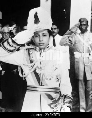 Le roi Fayçal II dans une photo commémorative, devant sa mère, la reine Alia, au palais Al Rehab à Bagdad. Faisal II (1935 ? 14 juillet 1958) fut le dernier roi d'Irak. Il règne du 4 avril 1939 jusqu'en juillet 1958, date à laquelle il est tué lors de la Révolution du 14 juillet. Ce régicide marqua la fin de la monarchie hachémite vieille de trente-sept ans en Irak, qui devint alors une république. Banque D'Images