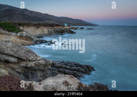 Les vagues s'écrasent doucement contre les falaises accidentées alors que le soleil se couche sur la plage d'État de Leo Carrillo à Malibu, en Californie, créant une atmosphère sereine. Banque D'Images